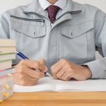 資格の勉強をする作業着姿の男性