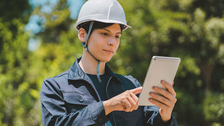 タブレットを操作する作業着姿の男性施工管理